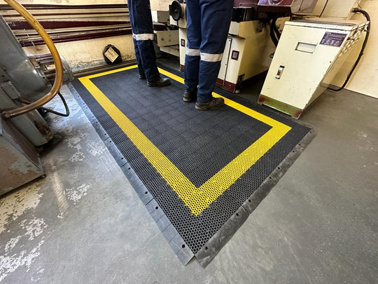 Man standing and working on anti fatigue mat