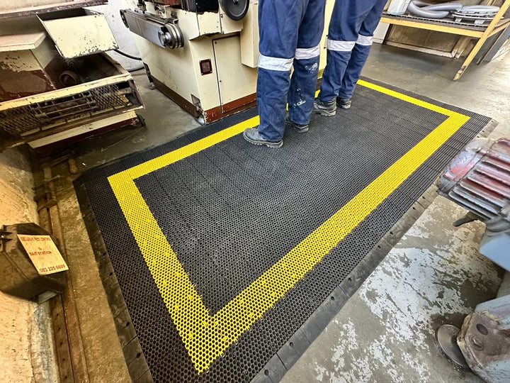 Men working while standing on anti fatigue mat 